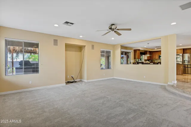 a view of a livingroom with wooden floor and a ceiling fan