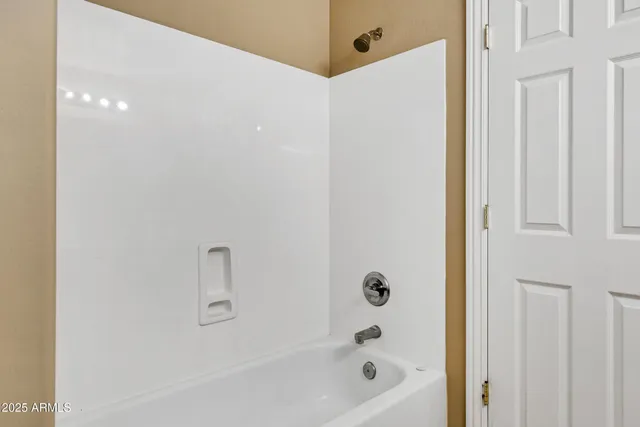 a view of an empty room and chandelier fan
