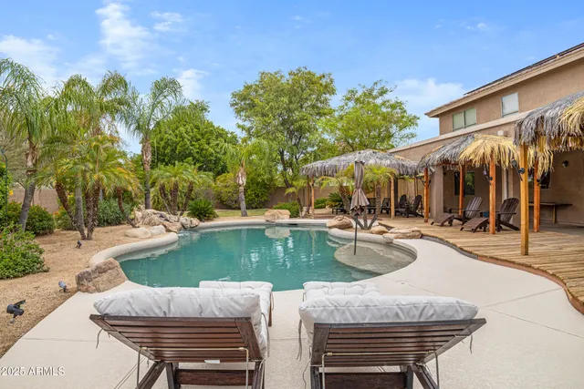 a view of a swimming pool with a patio and a yard with plants