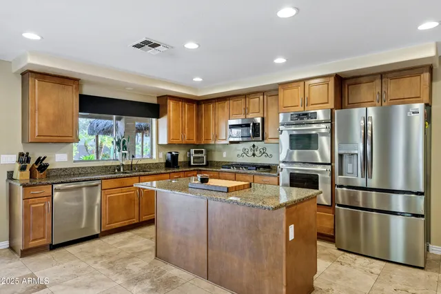 a kitchen with stainless steel appliances granite countertop a sink stove and refrigerator