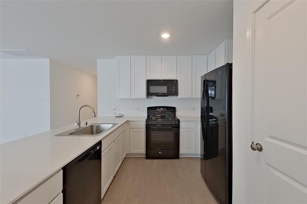 827 Ginkgo Way Princeton, TX 75407 - Photo 3 of 27 a kitchen with a refrigerator and a sink