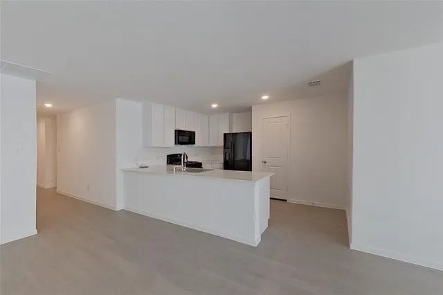 a large white kitchen with stainless steel appliances