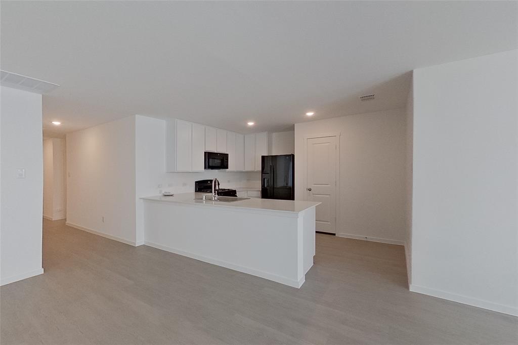 827 Ginkgo Way Princeton, TX 75407 - Photo 5 of 27 a large white kitchen with stainless steel appliances
