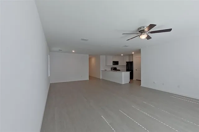 a view of a big room with windows and ceiling fan