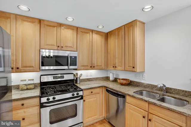 a kitchen with granite countertop a stove sink and cabinets