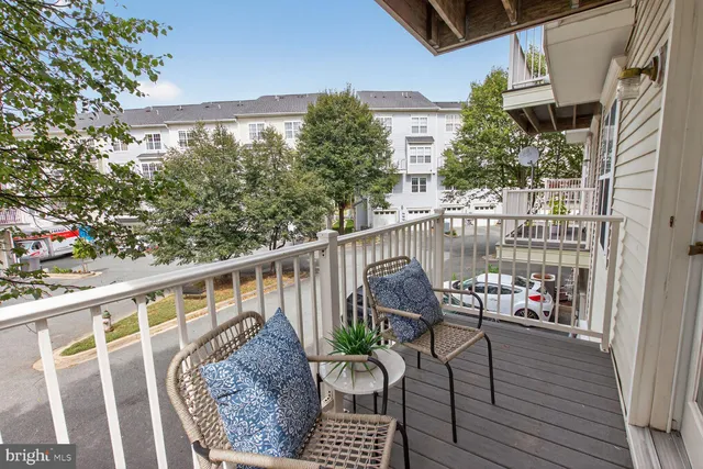 a balcony with wooden floor stairs and furniture