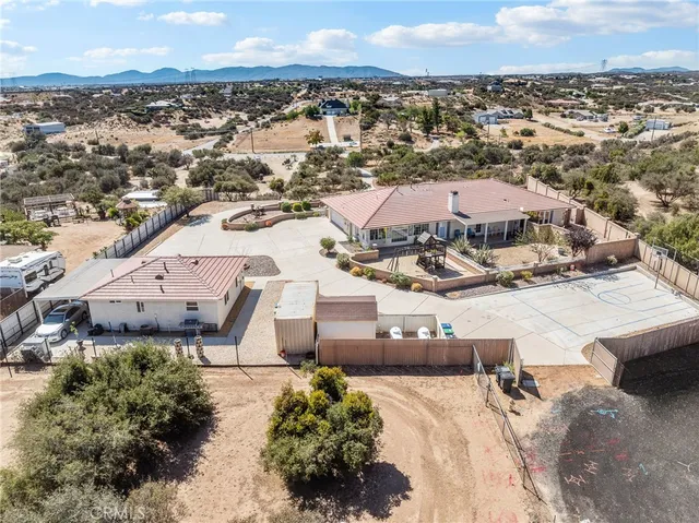 a front view of a house with yard and dining table and chairs under an umbrella