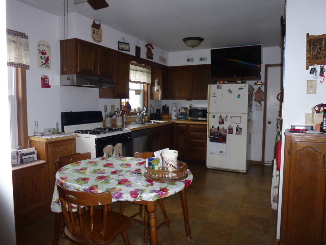 3 Deerefield Court Clinton, IL 61727 - Photo 6 of 29 a kitchen with stainless steel appliances kitchen island granite countertop a refrigerator a stove a sink a dining table and chairs with wooden floor