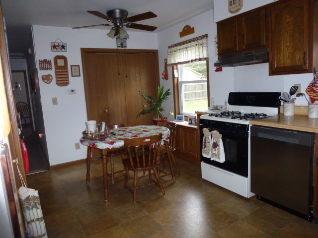 3 Deerefield Court Clinton, IL 61727 - Photo 7 of 29 a kitchen with stainless steel appliances granite countertop a stove a refrigerator a sink a dining table and chairs with wooden floor