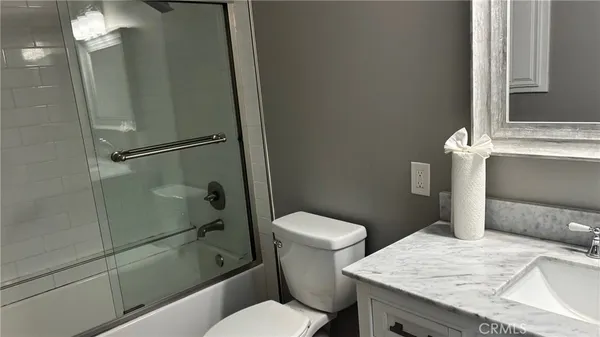 a bathroom with a granite countertop toilet sink and shower
