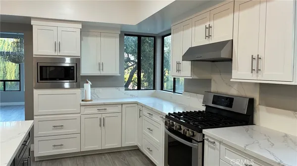 a kitchen with white cabinets and appliances