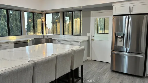 a kitchen with stainless steel appliances granite countertop a refrigerator and a sink
