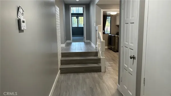 a view of a hallway with wooden floor and staircase