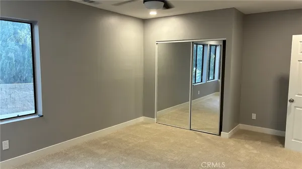an empty room with windows and closet