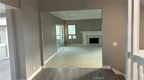 a view of a hallway with wooden floor and a living room