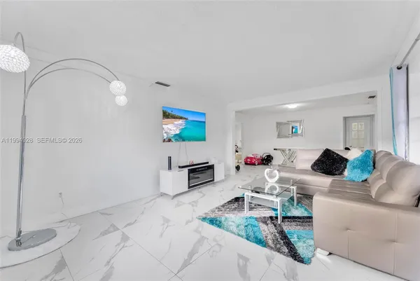 a living room with furniture and a wooden floor