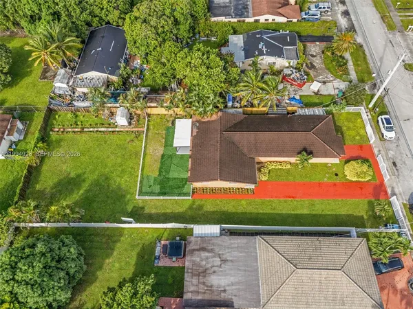 an aerial view of a house with a yard and a large pool