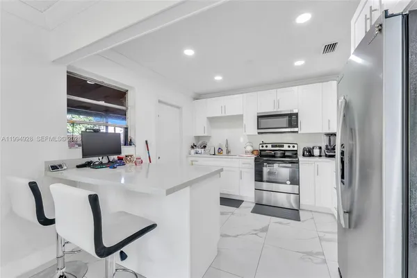 a kitchen with white cabinets and stainless steel appliances