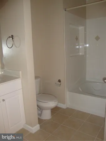a bathroom with a granite countertop sink a toilet and shower