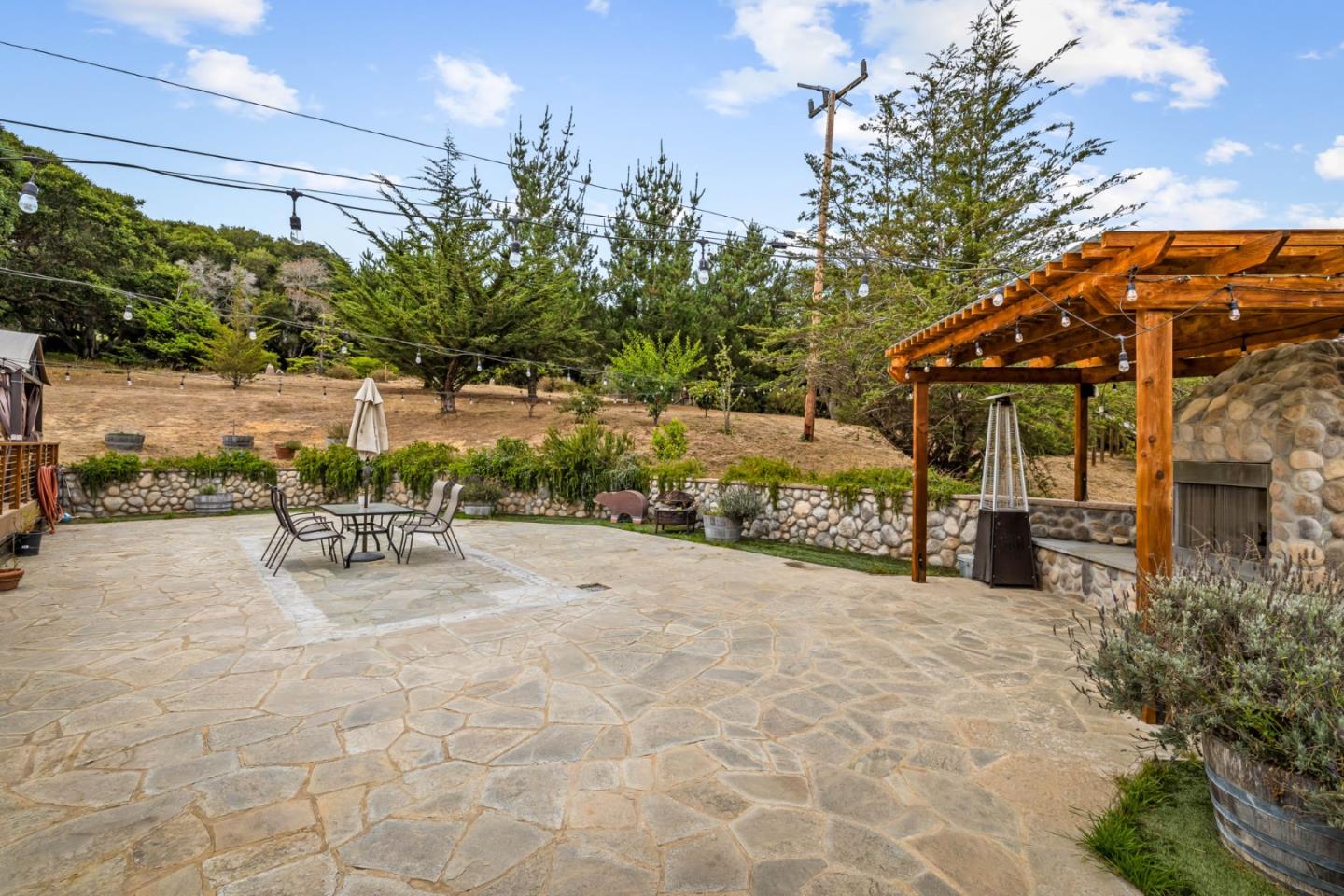 8697 Dyer Road Salinas, CA 93907 - Photo 77 of 94 a view of a patio with table and chairs under an umbrella with large trees
