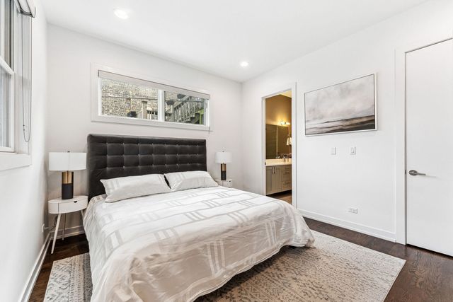 a bedroom with a bed and painting on the wall