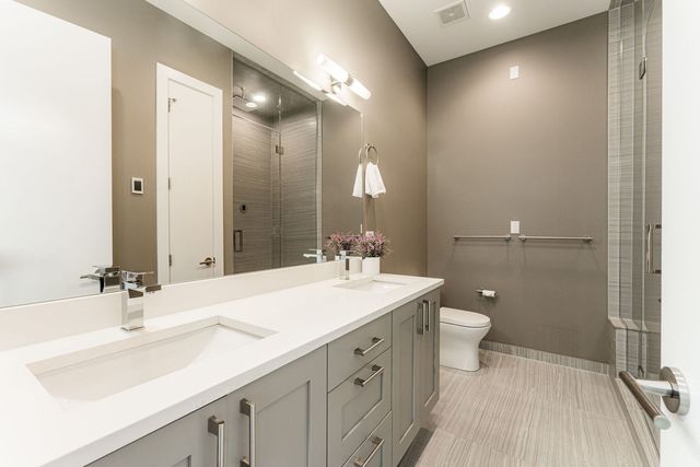 a bathroom with a sink double vanity and a toilet