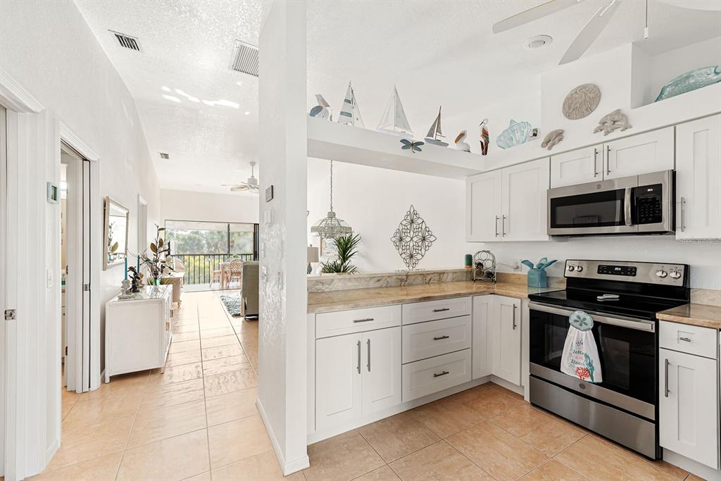 4260 Placida Road, Unit 12C Englewood, FL 34224 - Photo 18 of 57 a kitchen with stainless steel appliances kitchen island granite countertop a stove and a sink