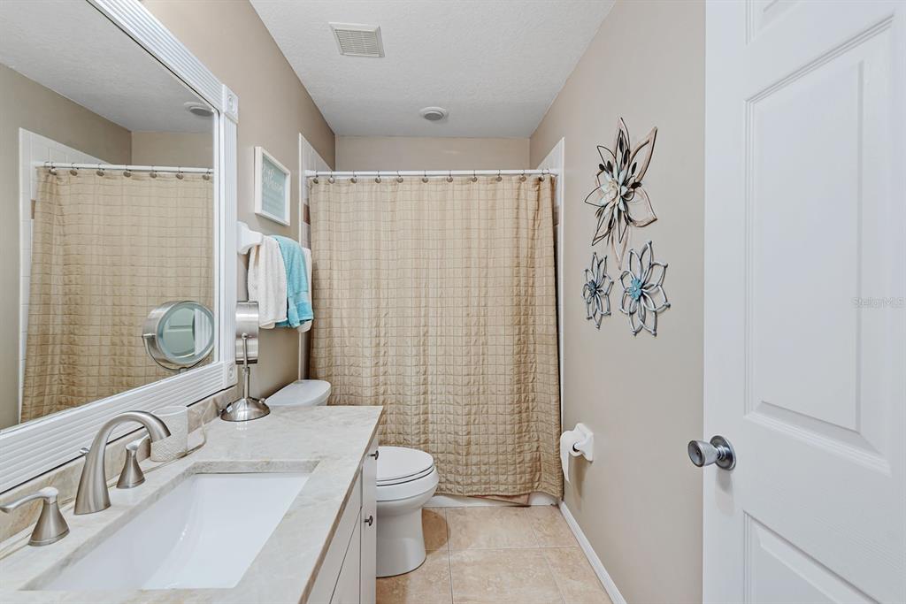 4260 Placida Road, Unit 12C Englewood, FL 34224 - Photo 32 of 57 a bathroom with a sink a toilet and shower curtain