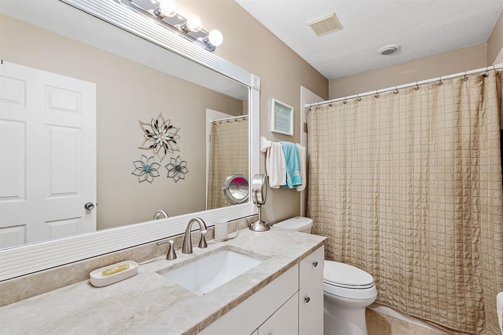 4260 Placida Road, Unit 12C Englewood, FL 34224 - Photo 33 of 57 a bathroom with a granite countertop sink toilet and shower