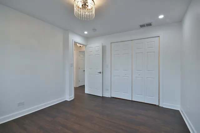 a view of a hallway with wooden floor and a window