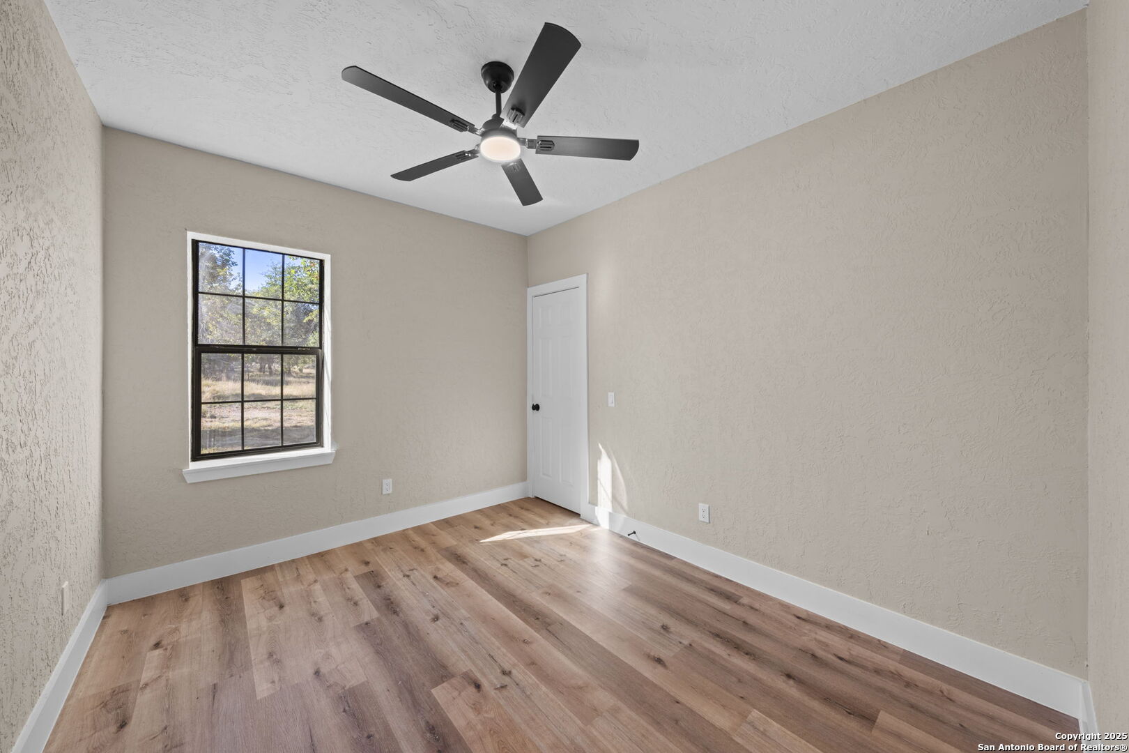 28 Ruger Road Fredericksburg, TX 78624 - Photo 26 of 46 an empty room with wooden floor fan and windows