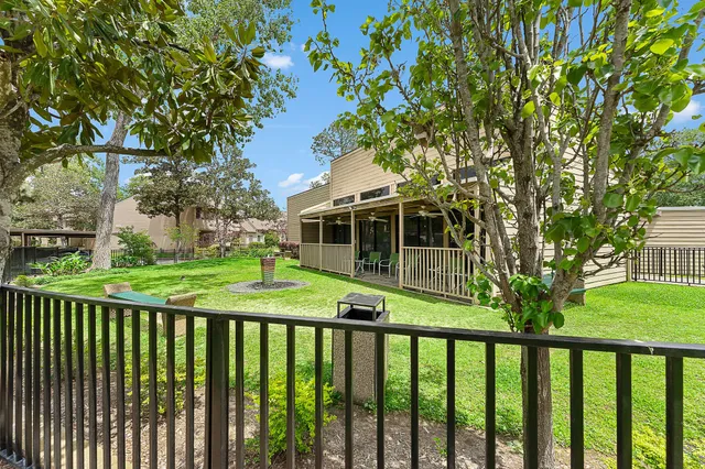 a view of a white house with a big yard and large trees