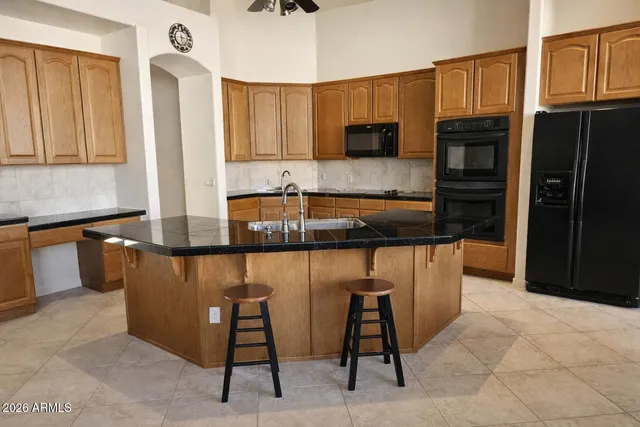 a kitchen with stainless steel appliances granite countertop a refrigerator and a stove top oven