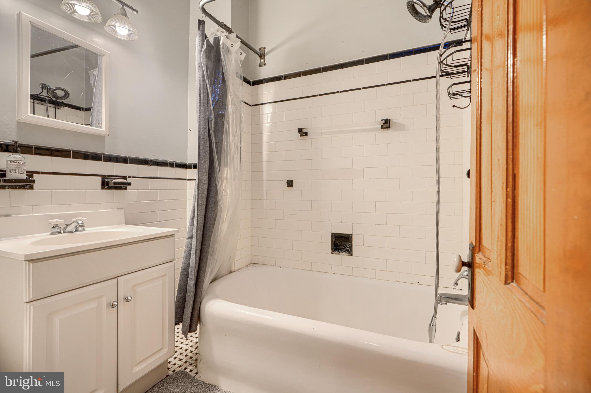 512 South Curley Street Baltimore, MD 21224 - Photo 25 of 29 a bathroom with a sink a mirror and a bathtub