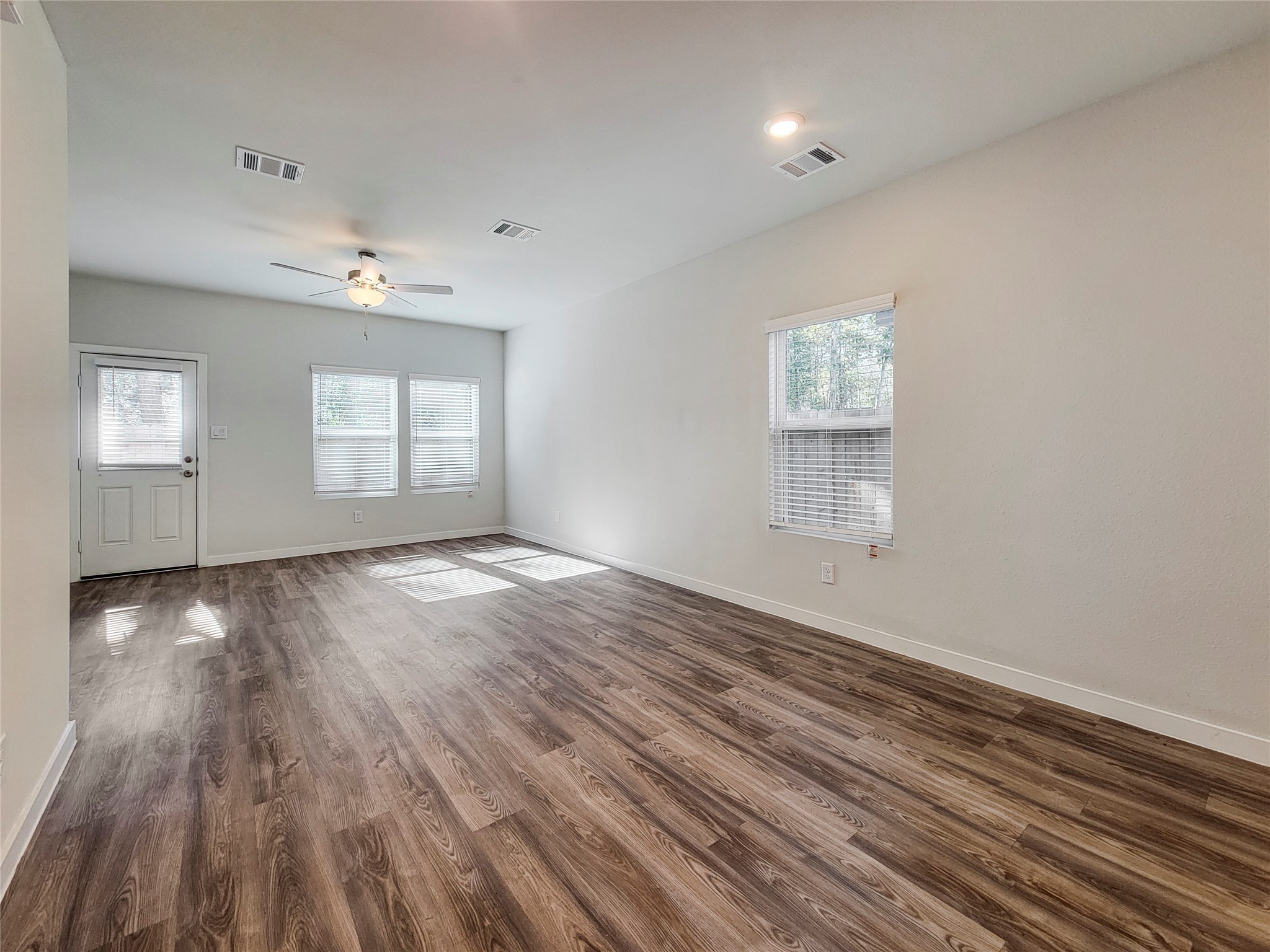 16954 Pandora Way Porter, TX 77365 - Photo 3 of 18 an empty room with wooden floor and windows