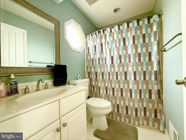 a bathroom with a sink a toilet and shower curtain