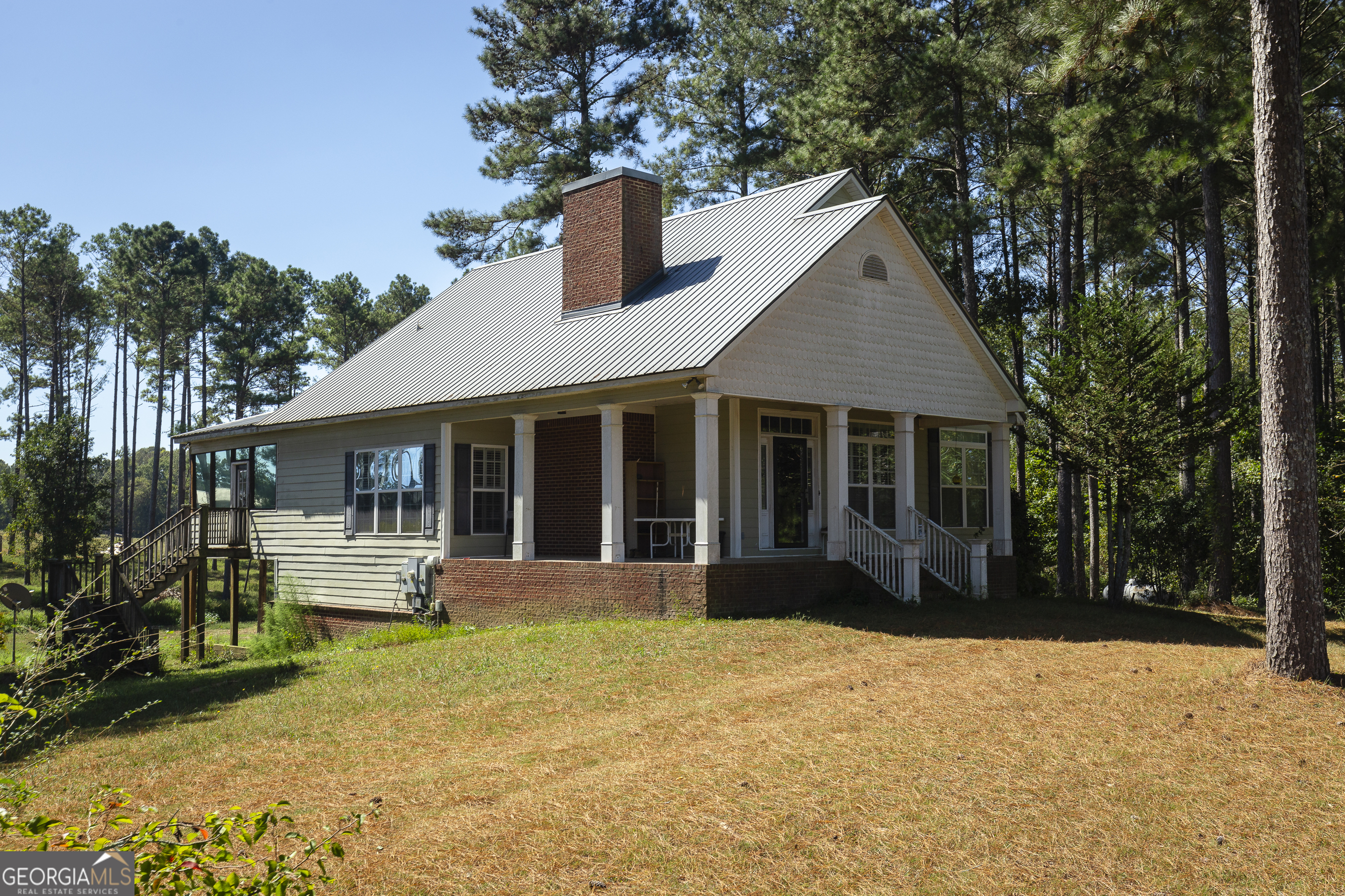 a front view of a house with a yard and potted plants