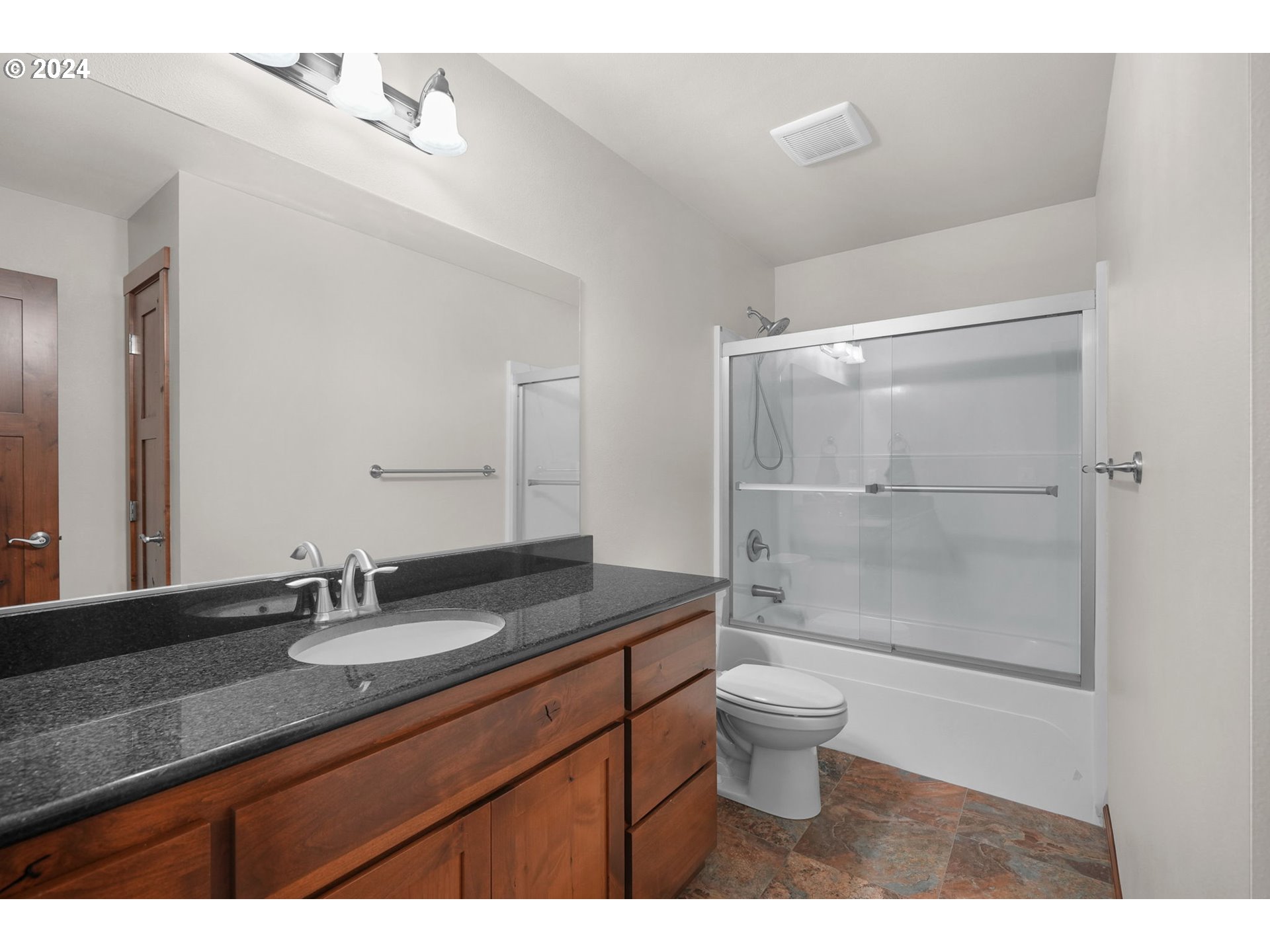 86002 Edenvale Road Pleasant Hill, OR 97455 - Photo 25 of 48 a bathroom with a granite countertop sink a toilet a mirror and shower