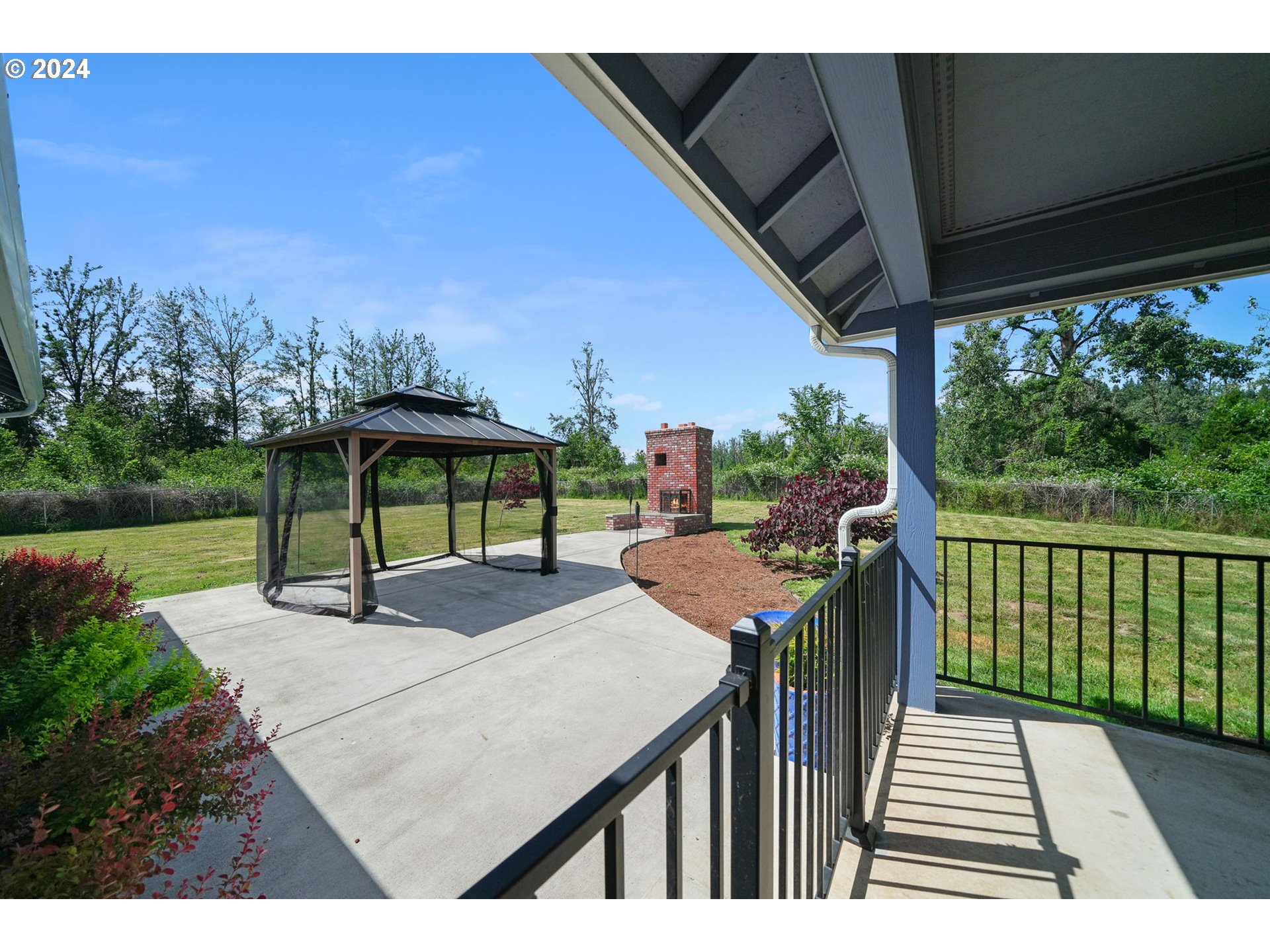 86002 Edenvale Road Pleasant Hill, OR 97455 - Photo 38 of 48 a view of a patio with table and chairs under an umbrella with a small yard