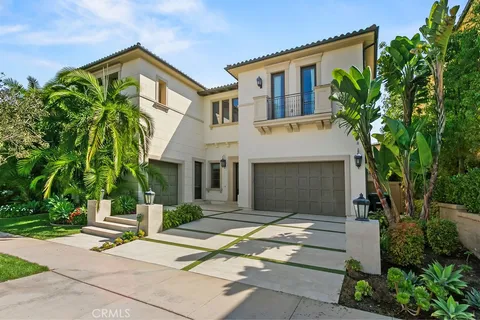 a front view of a house with a yard and potted plants