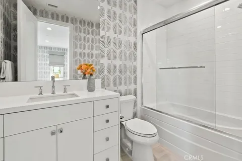 a bathroom with a sink a vanity a toilet and a window