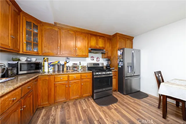 a kitchen with stainless steel appliances granite countertop a refrigerator a stove top oven a sink and dishwasher