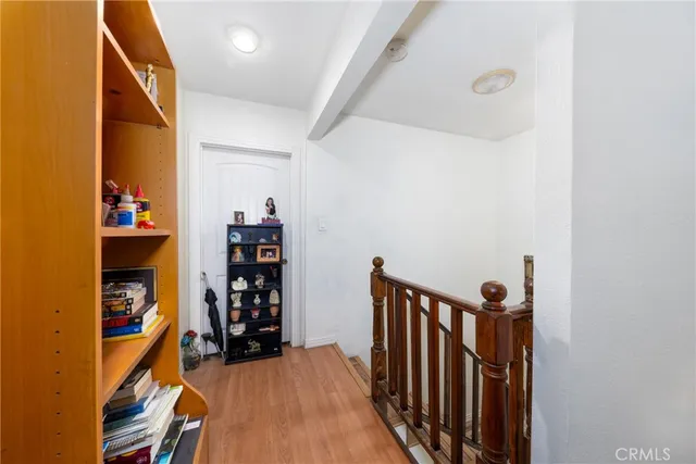 a view of a hallway with wooden floor and closet