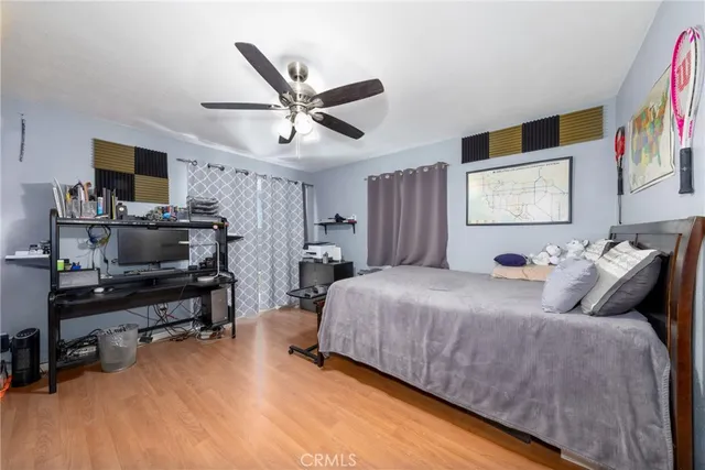 a spacious bedroom with a bed and a flat screen tv