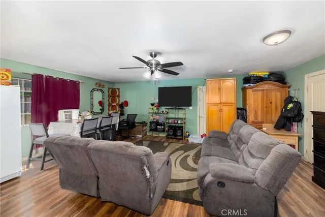 a living room with furniture kitchen view and a flat screen tv