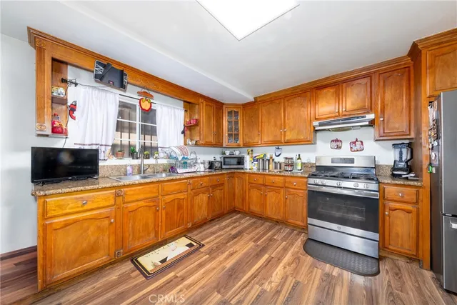 a kitchen with stainless steel appliances granite countertop a stove a sink and a refrigerator