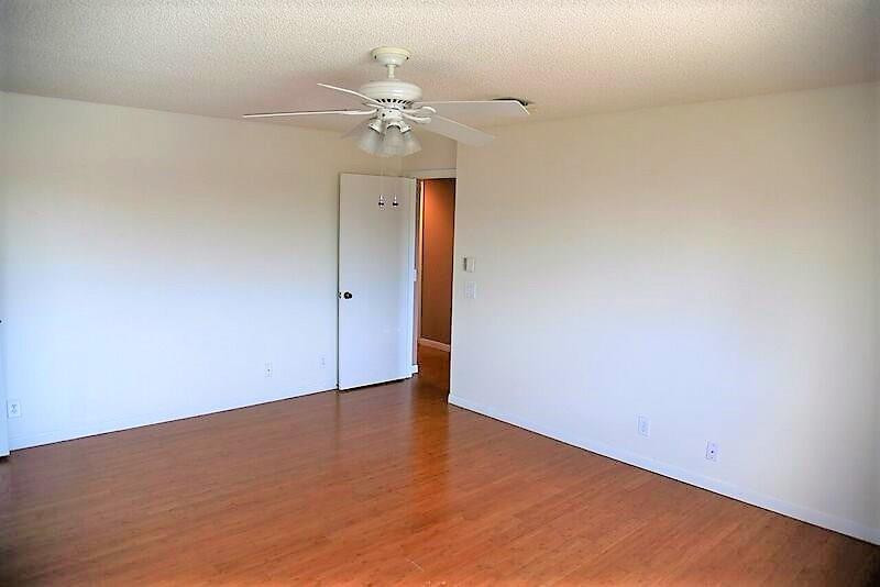 552 Talavera Road Weston, FL 33326 - Photo 14 of 16 an empty room with wooden floor and chandelier fan
