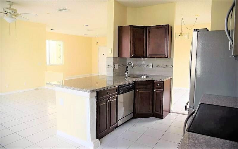 552 Talavera Road Weston, FL 33326 - Photo 9 of 16 a kitchen with stainless steel appliances granite countertop a stove and a refrigerator