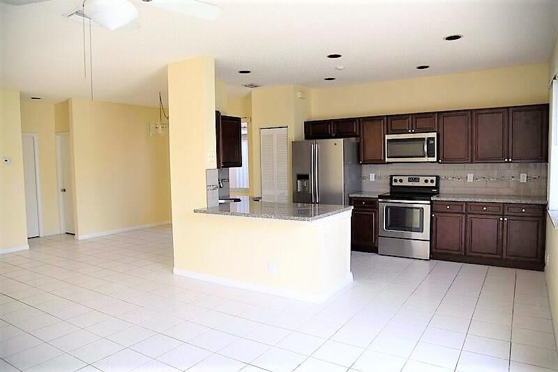 552 Talavera Road Weston, FL 33326 - Photo 10 of 16 a kitchen with stainless steel appliances a refrigerator sink and microwave