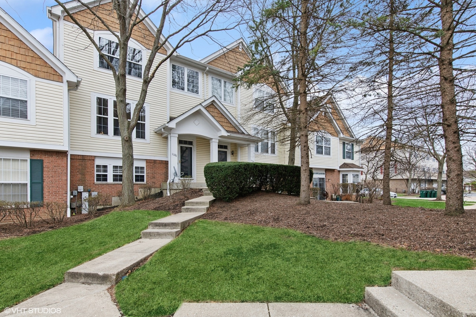1136 Georgetown Way Vernon Hills, IL 60061 - Photo 1 of 21 a front view of a house with a garden and trees